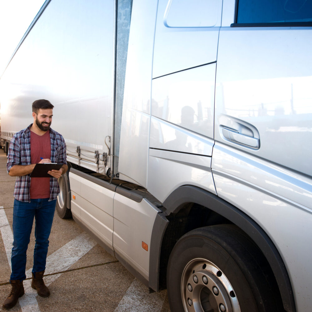 Truck driver occupation. Trucker checking vehicle condition. Experienced truck driver making visual inspection of truck before drive. Transportation service. Fleet vehicle inspection and appraisal services for business and commercial clients